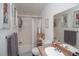 Bright bathroom featuring a shower-tub combo, neutral walls and ample storage at 1571 Sheridan Blvd, Lakewood, CO 80214