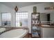 Serene bathroom with a soaking tub, glass block window and decorative lighting at 1571 Sheridan Blvd, Lakewood, CO 80214