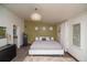 Modern bedroom featuring unique lighting fixture, green accent wall, and neutral color palette at 1571 Sheridan Blvd, Lakewood, CO 80214