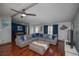 Bright living room with hardwood floors, large sectional sofa, and modern ceiling fan at 1571 Sheridan Blvd, Lakewood, CO 80214