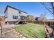 Large backyard featuring a lawn, garden beds, wood fence, and a deck at 3166 W Indian Summer Ln, Castle Rock, CO 80109