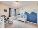 Bedroom featuring a crib, a chair, a window, neutral walls with a blue accent, and a carpeted floor at 3166 W Indian Summer Ln, Castle Rock, CO 80109