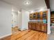 Charming bar area featuring wood cabinets, granite counters, hardwood floors and access to the basement at 5860 W Atlantic Dr, Lakewood, CO 80227
