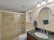 Bathroom features a tiled shower, granite countertop, and round mirror at 5860 W Atlantic Dr, Lakewood, CO 80227