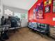 Bedroom featuring a black futon, desk, gaming computer and bold red walls adorned with posters at 5860 W Atlantic Dr, Lakewood, CO 80227