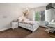 Bright bedroom with a white frame bed, side table and a big window with views of the outside at 5860 W Atlantic Dr, Lakewood, CO 80227