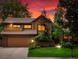 Charming two-story home with a well-manicured lawn and a two-car garage, all under a beautiful sunset at 5860 W Atlantic Dr, Lakewood, CO 80227