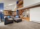 Bright and spacious living room featuring a comfortable brown sectional, blue pillows and hardwood floors at 5860 W Atlantic Dr, Lakewood, CO 80227