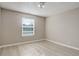 Empty bedroom featuring a window with blinds and wood-look flooring at 7165 S Gaylord St # E09, Centennial, CO 80122