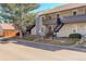 A charming exterior view of a two-story home with a beautiful tree and black metal staircases leading to the units at 7165 S Gaylord St # E09, Centennial, CO 80122
