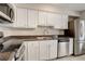 A lovely kitchen featuring stainless steel appliances, white cabinets, and dark countertops with a double basin sink at 7165 S Gaylord St # E09, Centennial, CO 80122