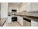 A lovely kitchen with stainless steel appliances, white cabinets, and dark countertops with a double basin sink at 7165 S Gaylord St # E09, Centennial, CO 80122