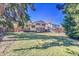 Large backyard with lush green lawn and mature trees, perfect for outdoor activities and relaxation at 3792 S Fenton Way, Denver, CO 80235