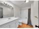 Bright bathroom with white vanity, a large mirror, and a combined bathtub and shower with a decorative curtain at 3792 S Fenton Way, Denver, CO 80235