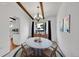 Dining room featuring modern chandelier, wood beams, and a marble table, perfect for entertaining at 3792 S Fenton Way, Denver, CO 80235