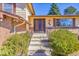 Inviting home entrance with double doors, brick accents, and landscaped bushes, offering a warm welcome at 3792 S Fenton Way, Denver, CO 80235