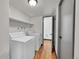 Bright laundry room features washer, dryer, shelving, and door to hallway at 3792 S Fenton Way, Denver, CO 80235