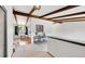 Bright living room with exposed beams, neutral carpet, and open floorplan that leads to the dining area at 3792 S Fenton Way, Denver, CO 80235