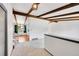 Open living area featuring exposed beams, white walls, and access to dining area with unique lighting at 3792 S Fenton Way, Denver, CO 80235