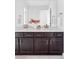 Bathroom featuring double vanity with sleek countertop, dark cabinets, and contemporary fixtures at 15977 Red Bud Dr, Parker, CO 80134