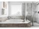 Spa-like bathroom featuring a soaking tub, tiled shower, and large window providing a tranquil retreat at 15977 Red Bud Dr, Parker, CO 80134