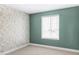 Cozy bedroom with neutral carpeting, sage accent wall, and floral wallpaper creating a stylish and inviting space at 15977 Red Bud Dr, Parker, CO 80134
