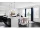Open concept kitchen and dining room with a center island, modern lighting, and backyard views at 15977 Red Bud Dr, Parker, CO 80134
