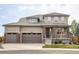 Charming two-story home featuring a welcoming front porch, three-car garage and manicured lawn at 15977 Red Bud Dr, Parker, CO 80134
