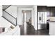 Bright foyer featuring dark wood floors, staircase with iron railing and stainless steel refrigerator at 15977 Red Bud Dr, Parker, CO 80134