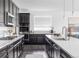 Gourmet kitchen featuring dark cabinets, stainless steel appliances, and a large center island with quartz countertops at 15977 Red Bud Dr, Parker, CO 80134