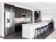 Modern kitchen with dark cabinets, a large center island with barstool seating, and stainless steel appliances at 15977 Red Bud Dr, Parker, CO 80134