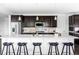 Modern kitchen with dark cabinets, a large center island with barstool seating, and stainless steel appliances at 15977 Red Bud Dr, Parker, CO 80134