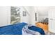 Bright bedroom featuring hardwood floors, white walls, and a comfortable blue quilt-covered bed at 2211 W 33Rd Ave, Denver, CO 80211