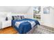 Bright bedroom with a large window, plush bedding, and decorative rug on hardwood floors at 2211 W 33Rd Ave, Denver, CO 80211