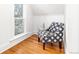 Cozy sitting area with hardwood floors, a patterned chair, and a sun-filled window at 2211 W 33Rd Ave, Denver, CO 80211