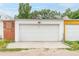 Exterior shot of a three-car garage with white doors and white and red brick siding at 2211 W 33Rd Ave, Denver, CO 80211