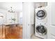Convenient laundry area with stacked washer and dryer, adjacent to dining area with hardwood floors at 2211 W 33Rd Ave, Denver, CO 80211