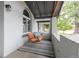 Relaxing porch with a wooden porch swing, striped rug, and gray painted walls at 2211 W 33Rd Ave, Denver, CO 80211