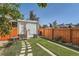 A fenced backyard with a seating area, barbecue and pathway of stepping stones through the grass at 493 S Lincoln St, Denver, CO 80209