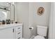 Clean bathroom with a black framed mirror, white cabinets, and modern fixtures at 493 S Lincoln St, Denver, CO 80209