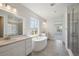 Modern bathroom with dual sinks, a freestanding tub, and a glass-enclosed shower at 13770 Emerald Lake St, Parker, CO 80138