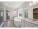 Modern bathroom featuring a soaking tub, dual vanities, and tiled flooring at 13770 Emerald Lake St, Parker, CO 80138