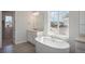 Bright bathroom featuring a freestanding tub by a window, and a dual sink vanity with a marble countertop at 13770 Emerald Lake St, Parker, CO 80138