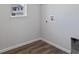 Well-lit laundry area featuring wood-look flooring and convenient utility connections at 13770 Emerald Lake St, Parker, CO 80138