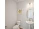 Simple half bath features a pedestal sink, modern lighting, and decorative lemon artwork at 13770 Emerald Lake St, Parker, CO 80138