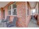 Brick front porch with gray metal chairs and side yard view at 2799 Syracuse Ct, Denver, CO 80238