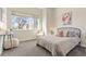 Sunlit bedroom features a large window, plush carpet, and cozy decor at 2321 Eliot St, Denver, CO 80211