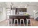 Modern kitchen featuring stainless steel appliances, a sleek island with seating, and open shelving at 2321 Eliot St, Denver, CO 80211