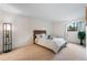 Bedroom featuring plush carpet, a window with curtains, and a modern floor lamp at 201 Wright St # 106, Lakewood, CO 80228