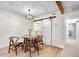 Dining area with wood floors, decorative light fixture and a closet behind a sliding barn door at 201 Wright St # 106, Lakewood, CO 80228